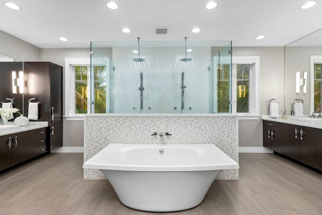 bathroom with independent shower and bath, vanity, hardwood / wood-style flooring, and a wealth of natural light