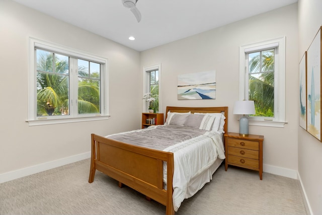 carpeted bedroom with ceiling fan and multiple windows