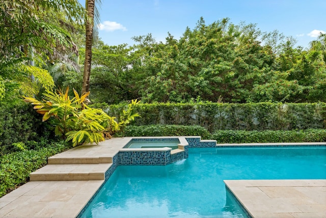 view of swimming pool with an in ground hot tub