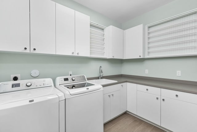 laundry area featuring cabinets, washer and clothes dryer, and sink