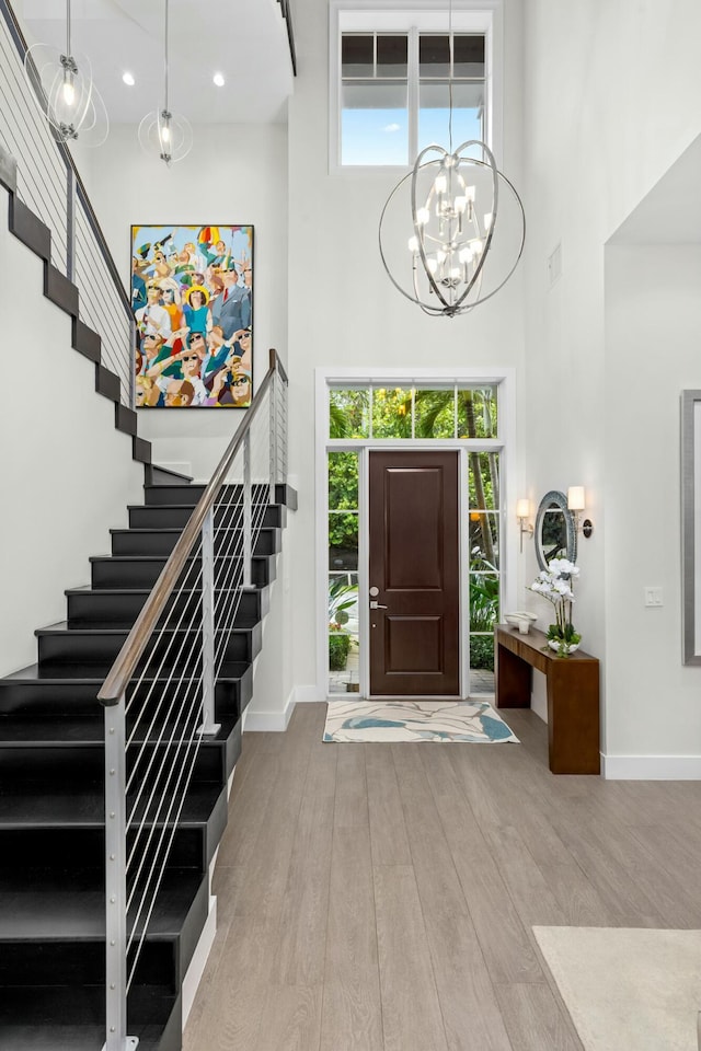 entryway with a chandelier, light hardwood / wood-style flooring, and a high ceiling