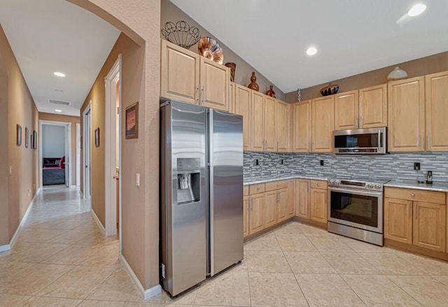 kitchen featuring decorative backsplash, light tile patterned flooring, stainless steel appliances, and light brown cabinetry