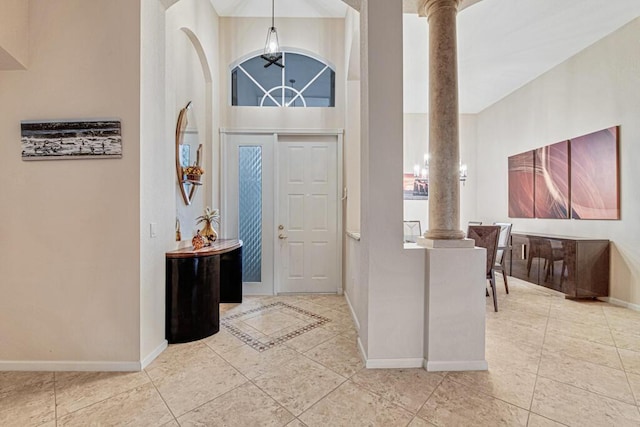 foyer entrance with a towering ceiling and ornate columns