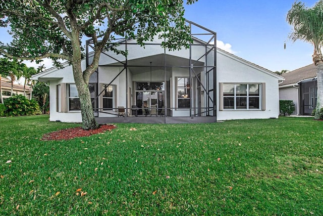 rear view of property featuring a yard and glass enclosure