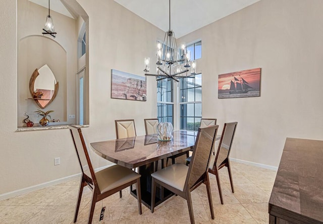 dining room featuring a notable chandelier, light tile patterned floors, and a towering ceiling