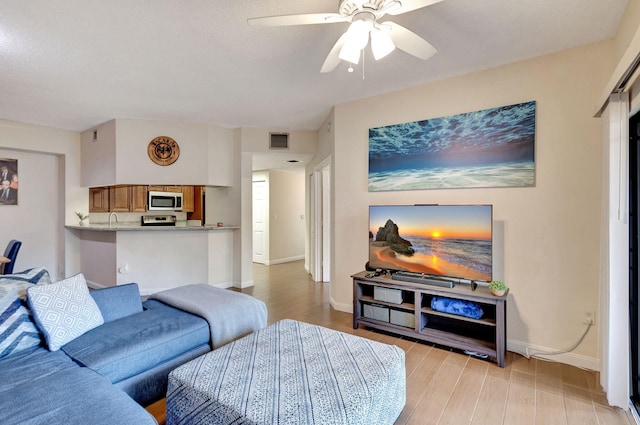 living room with light hardwood / wood-style flooring and ceiling fan