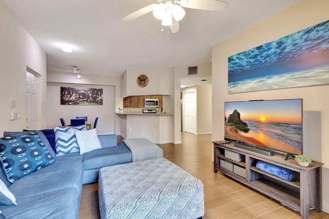 living room with light hardwood / wood-style floors and ceiling fan