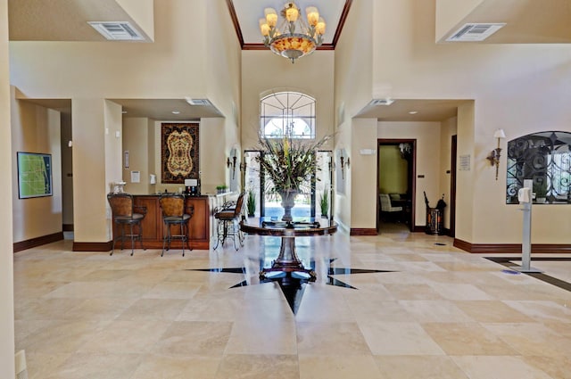 entryway with a towering ceiling and a chandelier