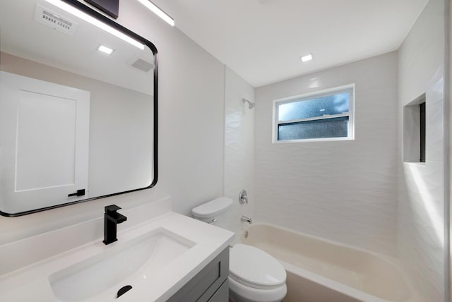 full bathroom featuring vanity, tiled shower / bath combo, and toilet