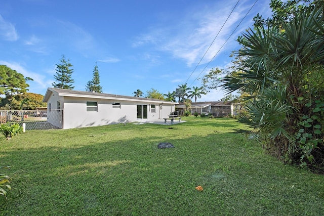 back of property with a patio area and a yard