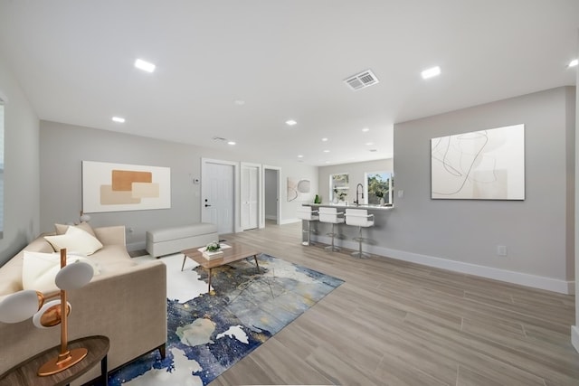 living room featuring sink and light hardwood / wood-style flooring