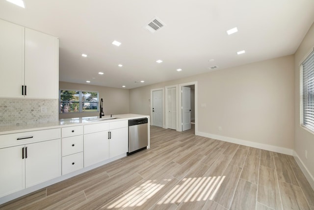 kitchen with white cabinets, tasteful backsplash, stainless steel dishwasher, and sink