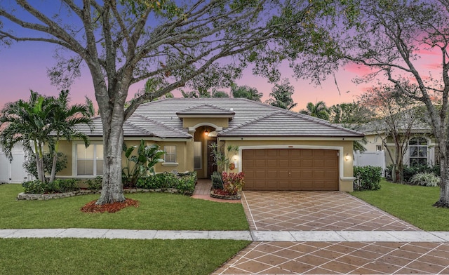 ranch-style house featuring a yard and a garage