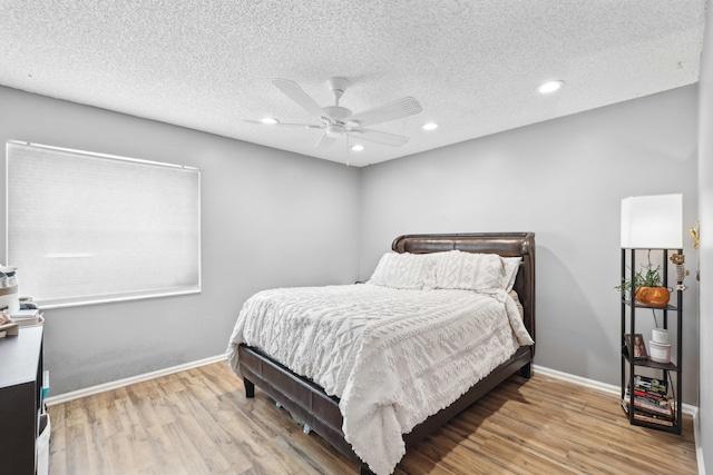 bedroom featuring a textured ceiling, ceiling fan, and light wood-type flooring