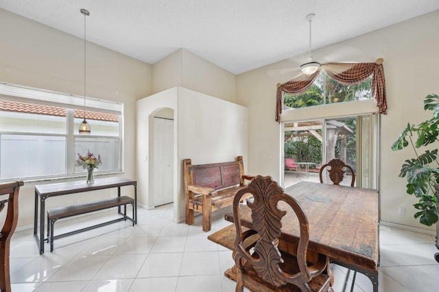 dining area featuring a towering ceiling and light tile patterned flooring