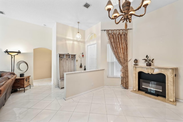 tiled living room featuring a textured ceiling and a chandelier