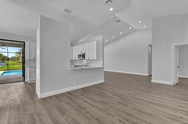 unfurnished living room featuring light hardwood / wood-style floors and high vaulted ceiling