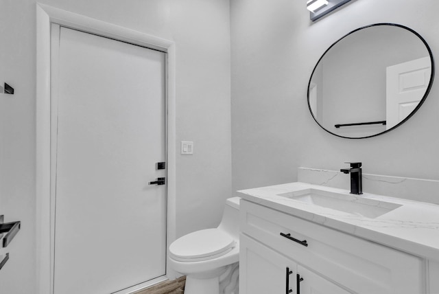 bathroom featuring hardwood / wood-style floors, vanity, and toilet