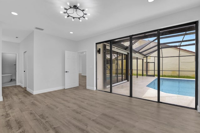 interior space featuring a chandelier, connected bathroom, access to outside, and light hardwood / wood-style flooring