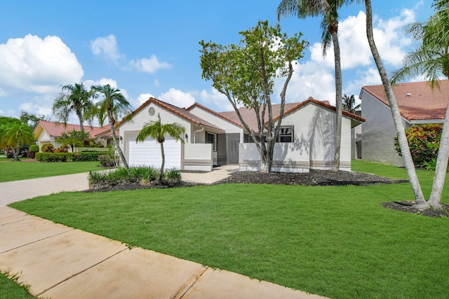 mediterranean / spanish house featuring a garage and a front lawn