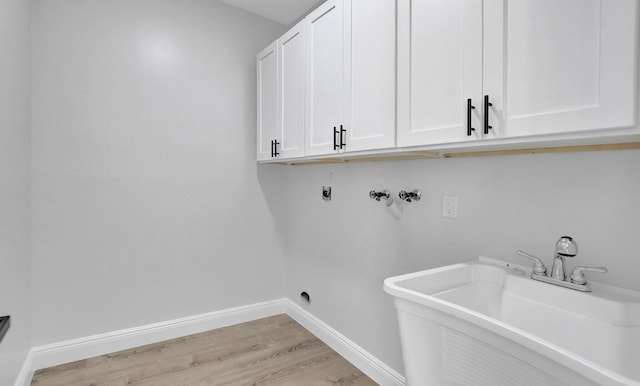 laundry room featuring electric dryer hookup, cabinets, sink, washer hookup, and light hardwood / wood-style floors