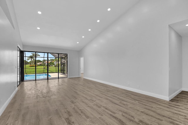 unfurnished living room with light hardwood / wood-style flooring and high vaulted ceiling