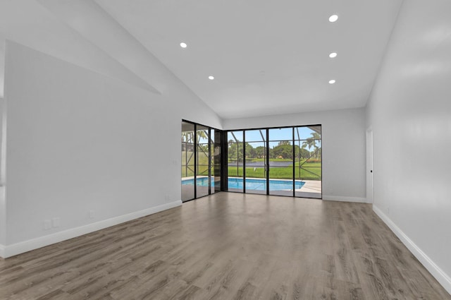 empty room featuring light hardwood / wood-style floors and high vaulted ceiling