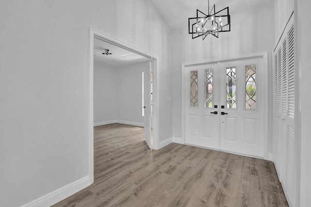 foyer entrance featuring light hardwood / wood-style flooring and a notable chandelier