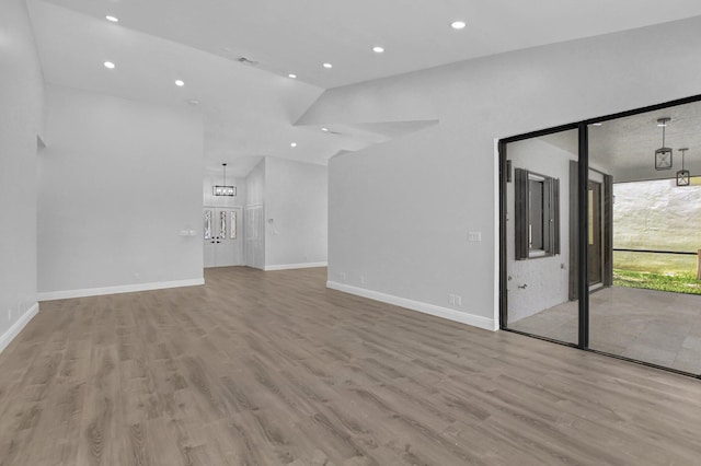 unfurnished living room featuring light hardwood / wood-style flooring and vaulted ceiling