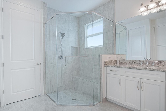 bathroom with a shower with door and vanity