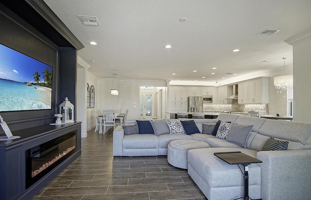 living room featuring a chandelier and ornamental molding