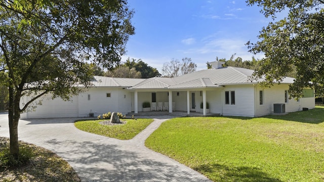 ranch-style house with central AC unit, a garage, covered porch, and a front yard