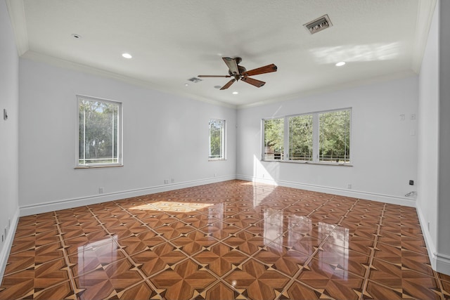 spare room with dark parquet flooring, ceiling fan, and crown molding