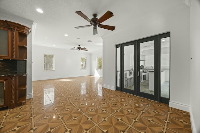 interior space with ornamental molding, french doors, a textured ceiling, and ceiling fan