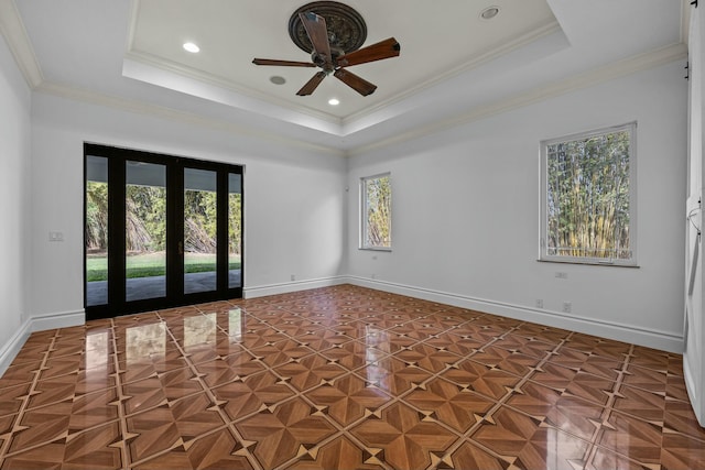 spare room with ceiling fan, ornamental molding, and a tray ceiling