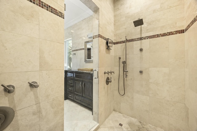 bathroom with a tile shower and vanity