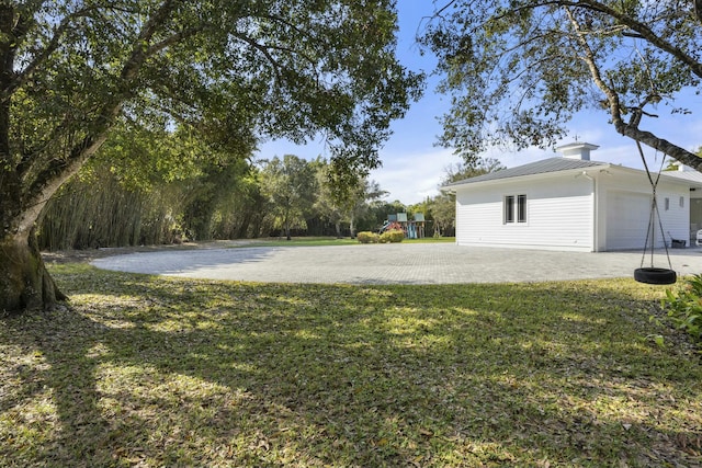 view of yard with a playground and a garage