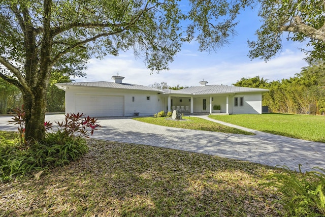 single story home with a garage and a front lawn