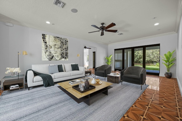 living room featuring tile patterned flooring, ceiling fan, ornamental molding, and a textured ceiling