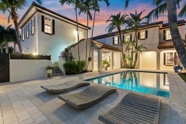 pool at dusk with a patio