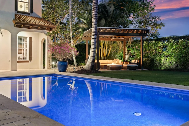 pool at dusk with an outdoor hangout area, a pergola, a lawn, and a patio