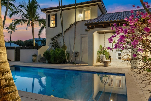 exterior space with a fenced in pool and a patio