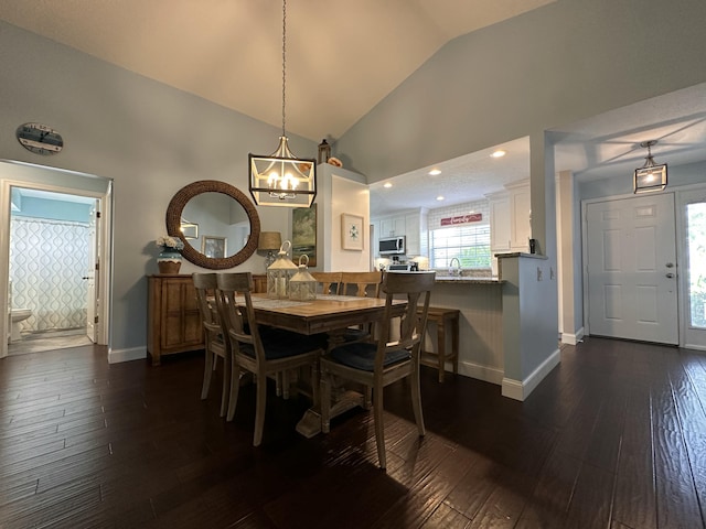 dining room featuring dark hardwood / wood-style floors, high vaulted ceiling, and sink