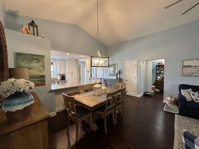 dining space with lofted ceiling, dark wood-type flooring, and a chandelier