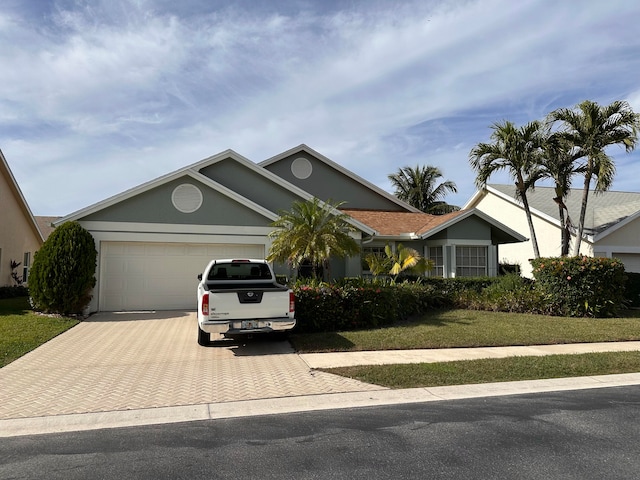 single story home with a garage and a front lawn