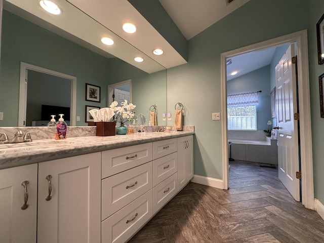 bathroom featuring parquet floors, a bathtub, vanity, and lofted ceiling