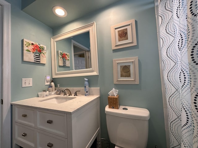 bathroom featuring a shower with shower curtain, vanity, and toilet