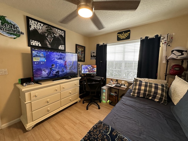 bedroom featuring ceiling fan, light hardwood / wood-style floors, and a textured ceiling