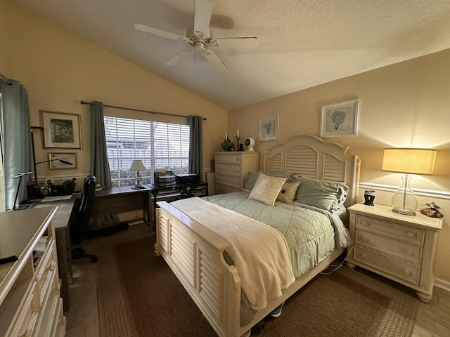 bedroom with ceiling fan, lofted ceiling, and a textured ceiling