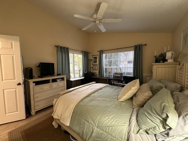 bedroom featuring ceiling fan, light wood-type flooring, and vaulted ceiling